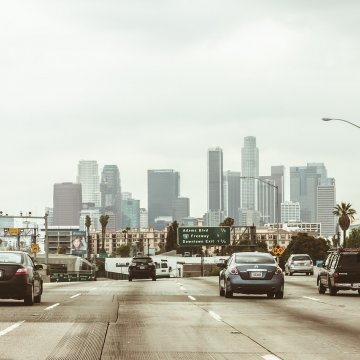 a busy highway with lots of cars travelling into the city 